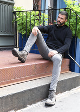 Complete look on a sitting model ARI Cashmere Knit Hoodie Black. Made in Italy